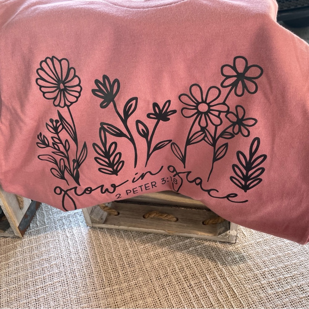 Growing in Grace. Cotton 100% so will shrink a little.